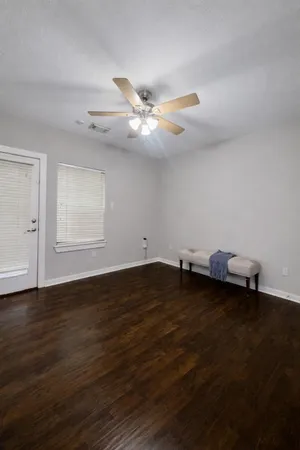a view of a room with wooden floor and a ceiling fan