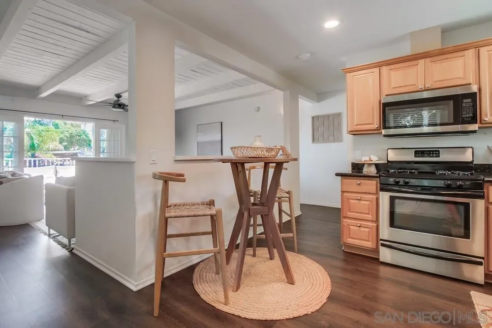 303-305 Sanford Street Encinitas, CA 92024 - Photo 11 of 41 a kitchen with stainless steel appliances a stove a microwave a dining table and chairs