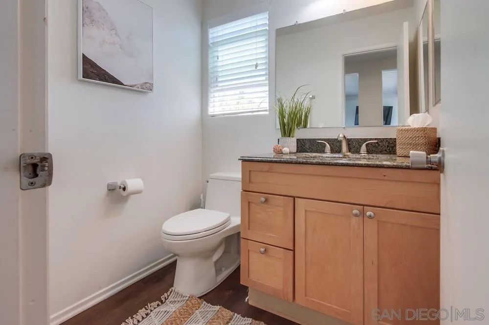303-305 Sanford Street Encinitas, CA 92024 - Photo 12 of 41 a bathroom with a granite countertop toilet sink and mirror