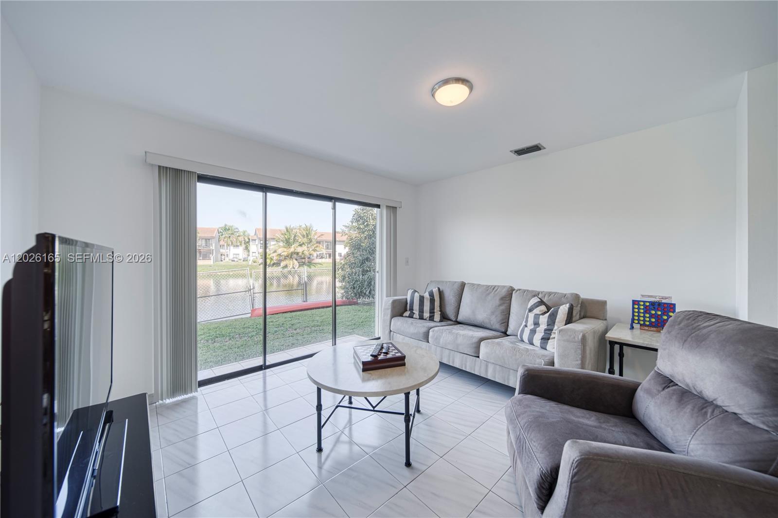 13337 Southwest 64th Lane Miami, FL 33183 - Photo 18 of 36 a living room with furniture and a flat screen tv