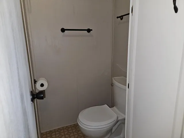 a white toilet sitting next to a shower