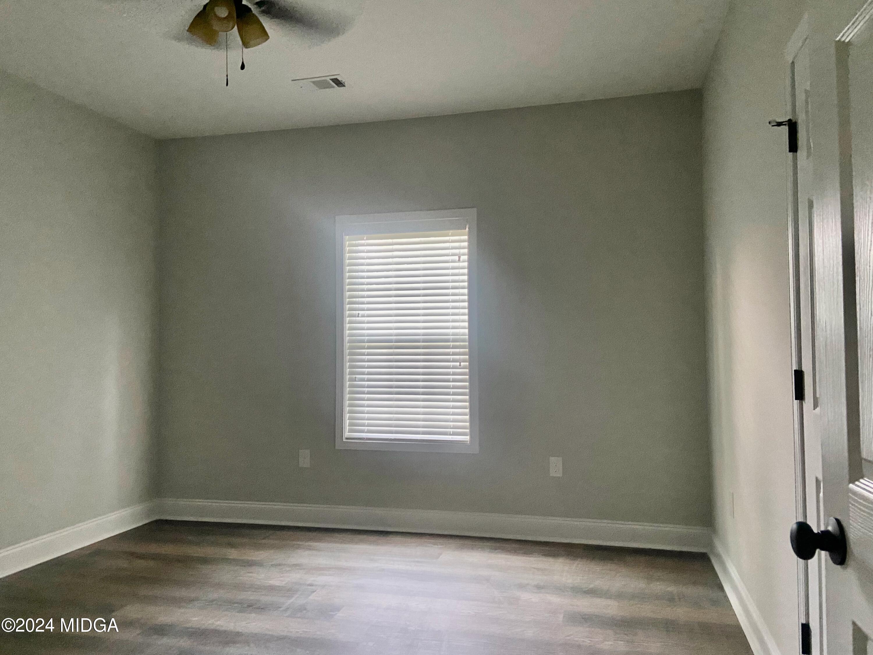 426 Walker Road Byron, GA 31008 - Photo 13 of 24 an empty room with wooden floor and windows