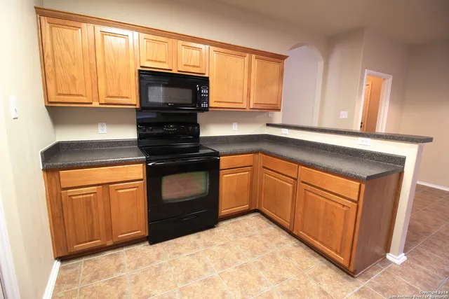 a kitchen with granite countertop cabinets stainless steel appliances and a window