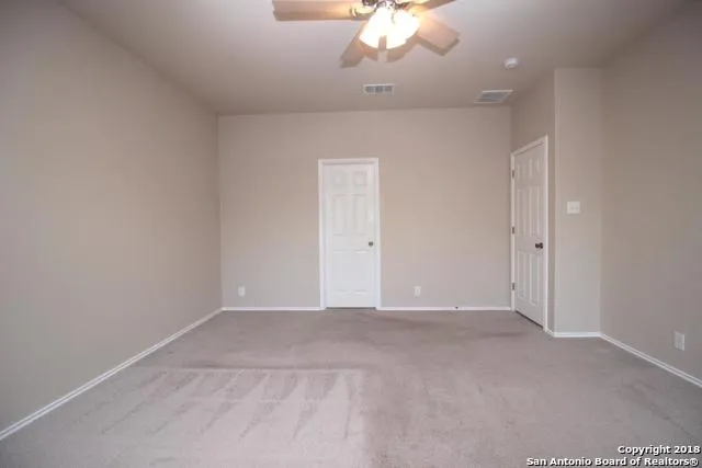an empty room with a chandelier fan