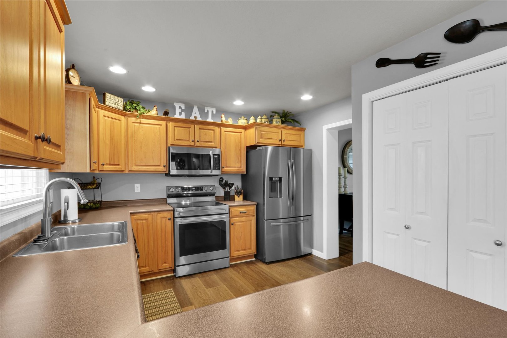3808 Pebblebrook Lane Champaign, IL 61822 - Photo 15 of 31 a kitchen with stainless steel appliances granite countertop a refrigerator a stove and a sink with wooden floor