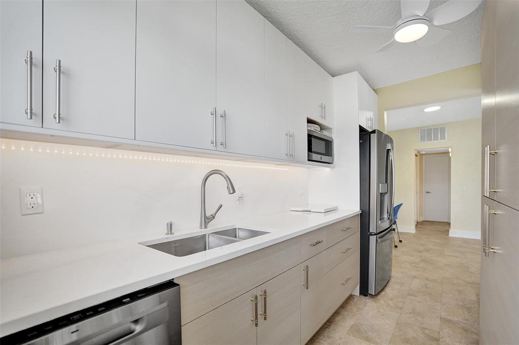 5700 Old Ocean Boulevard, Unit X Ocean Ridge, FL 33435 - Photo 11 of 49 a kitchen with a sink and refrigerator