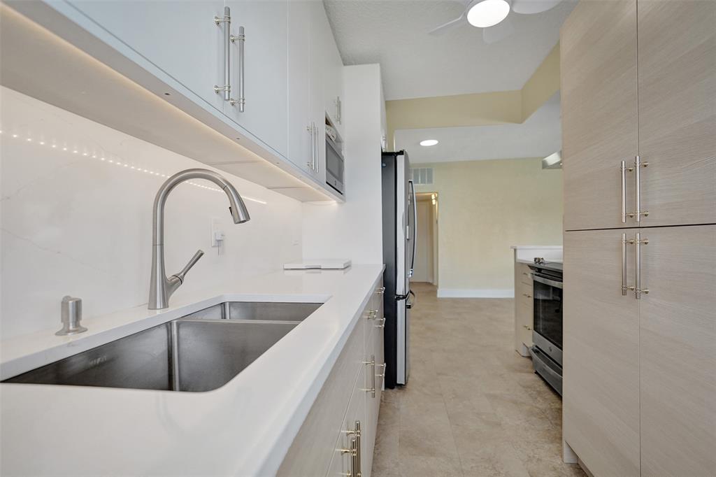 5700 Old Ocean Boulevard, Unit X Ocean Ridge, FL 33435 - Photo 13 of 49 a kitchen with a refrigerator sink and cabinets