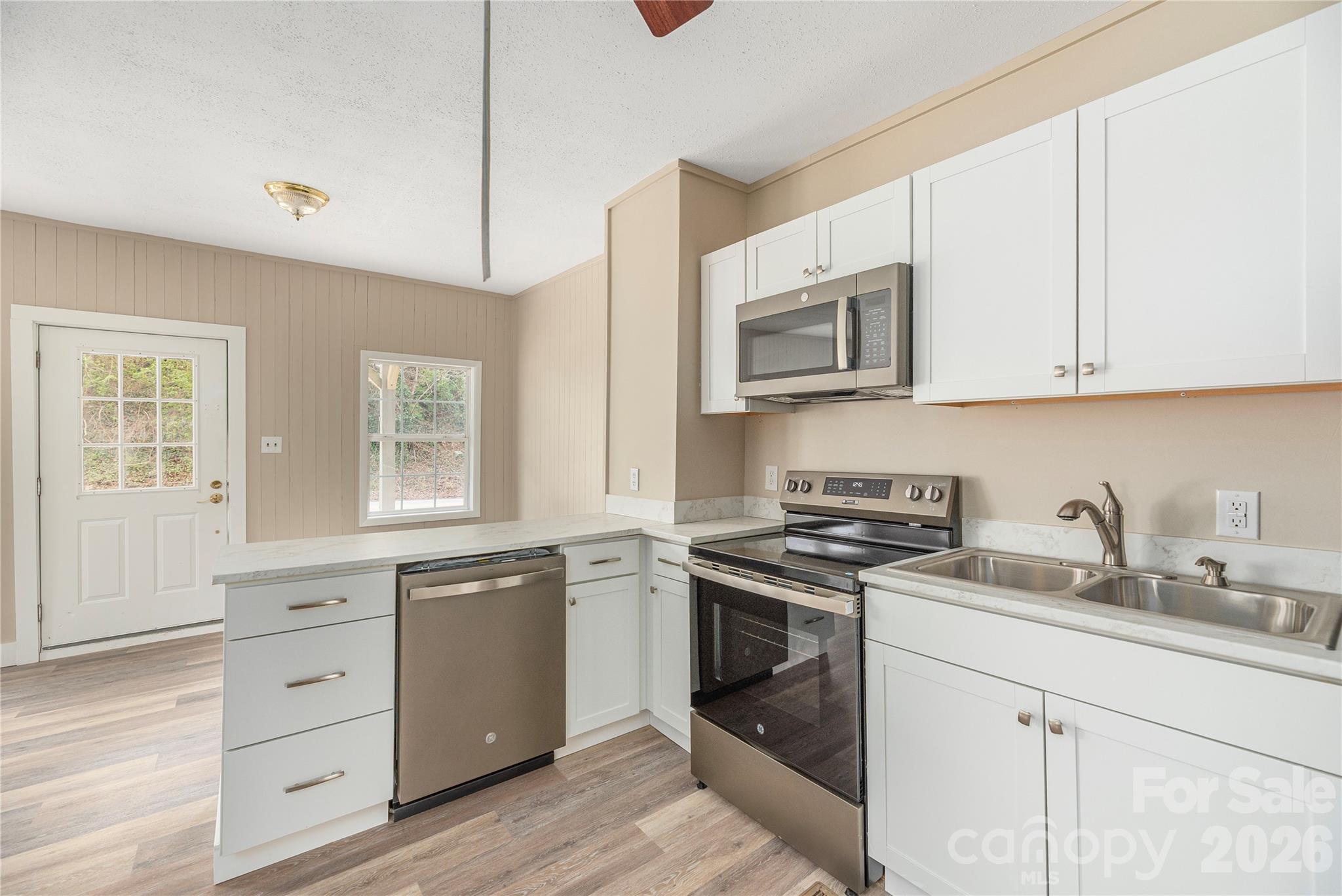 448 Sand Hill Road Asheville, NC 28806 - Photo 7 of 24 a kitchen with white cabinets stainless steel appliances and sink
