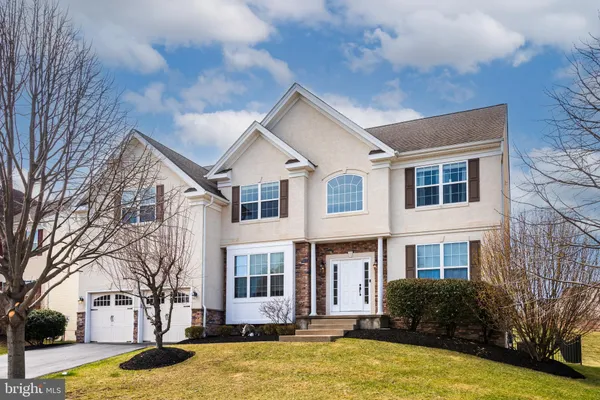 a view of a white house with a yard and large tree
