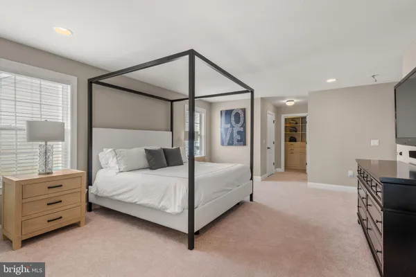 a bedroom with a bed a mirror and a dresser