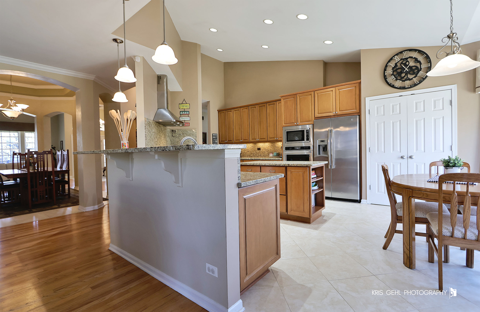 317 Sterling Circle Cary, IL 60013 - Photo 12 of 47 a kitchen with stainless steel appliances granite countertop a stove top oven a sink a dining table and chairs with wooden floor