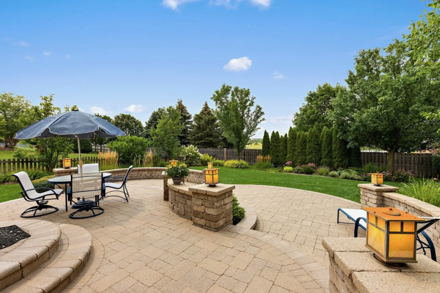 317 Sterling Circle Cary, IL 60013 - Photo 38 of 47 a view of a patio with table and chairs under an umbrella with large trees