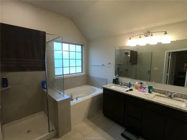 a bathroom with a tub sink and mirror