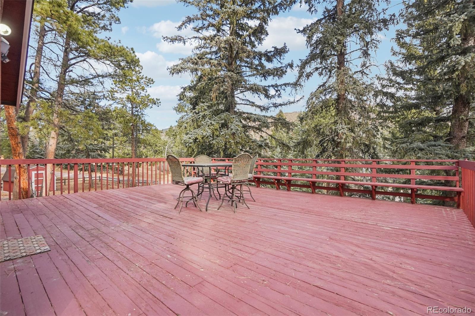 9025 Picabo Road Cascade, CO 80809 - Photo 15 of 44 a view of a terrace with chairs and wooden fence