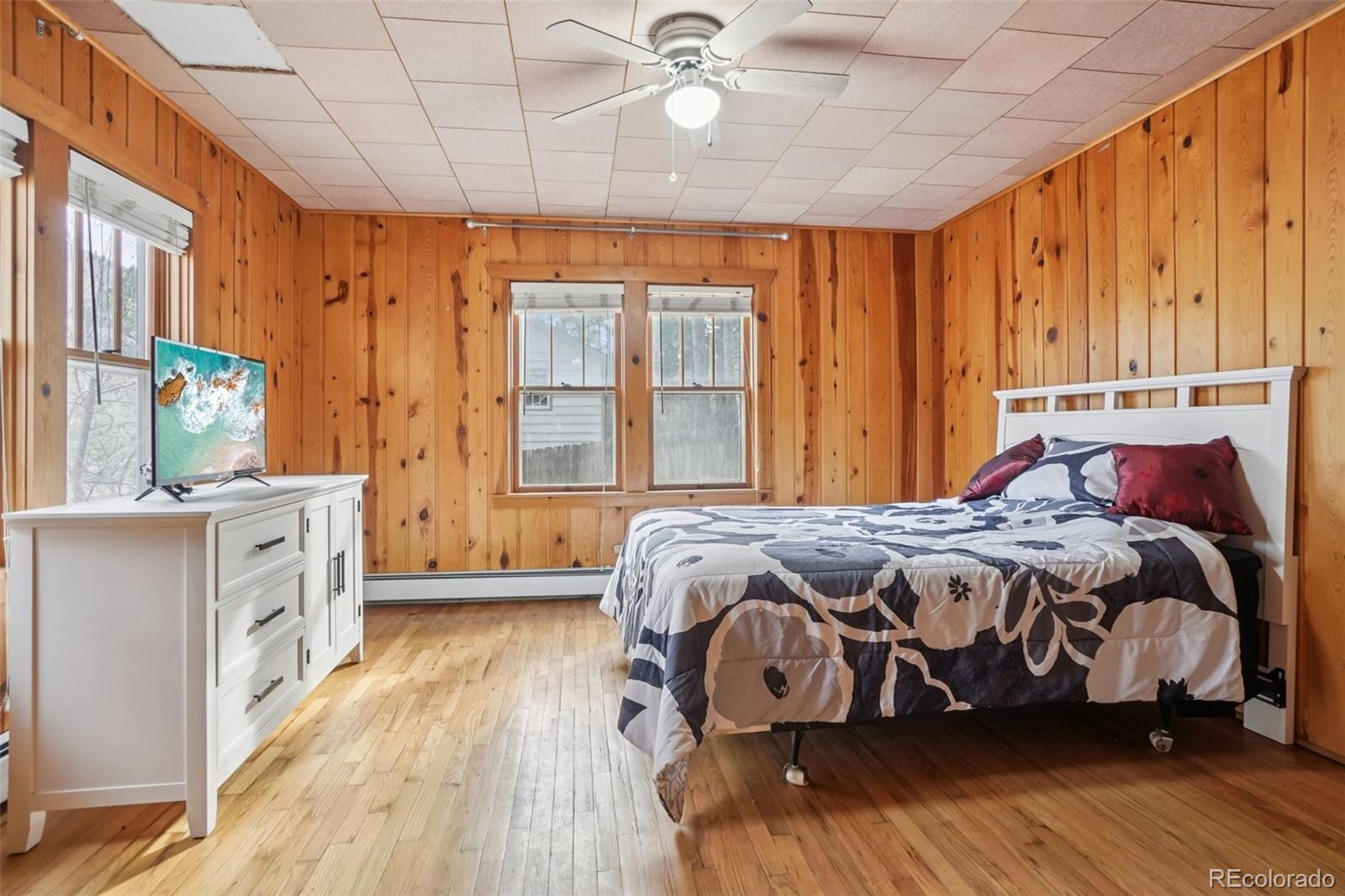 9025 Picabo Road Cascade, CO 80809 - Photo 22 of 44 a bedroom with a bed and a chandelier