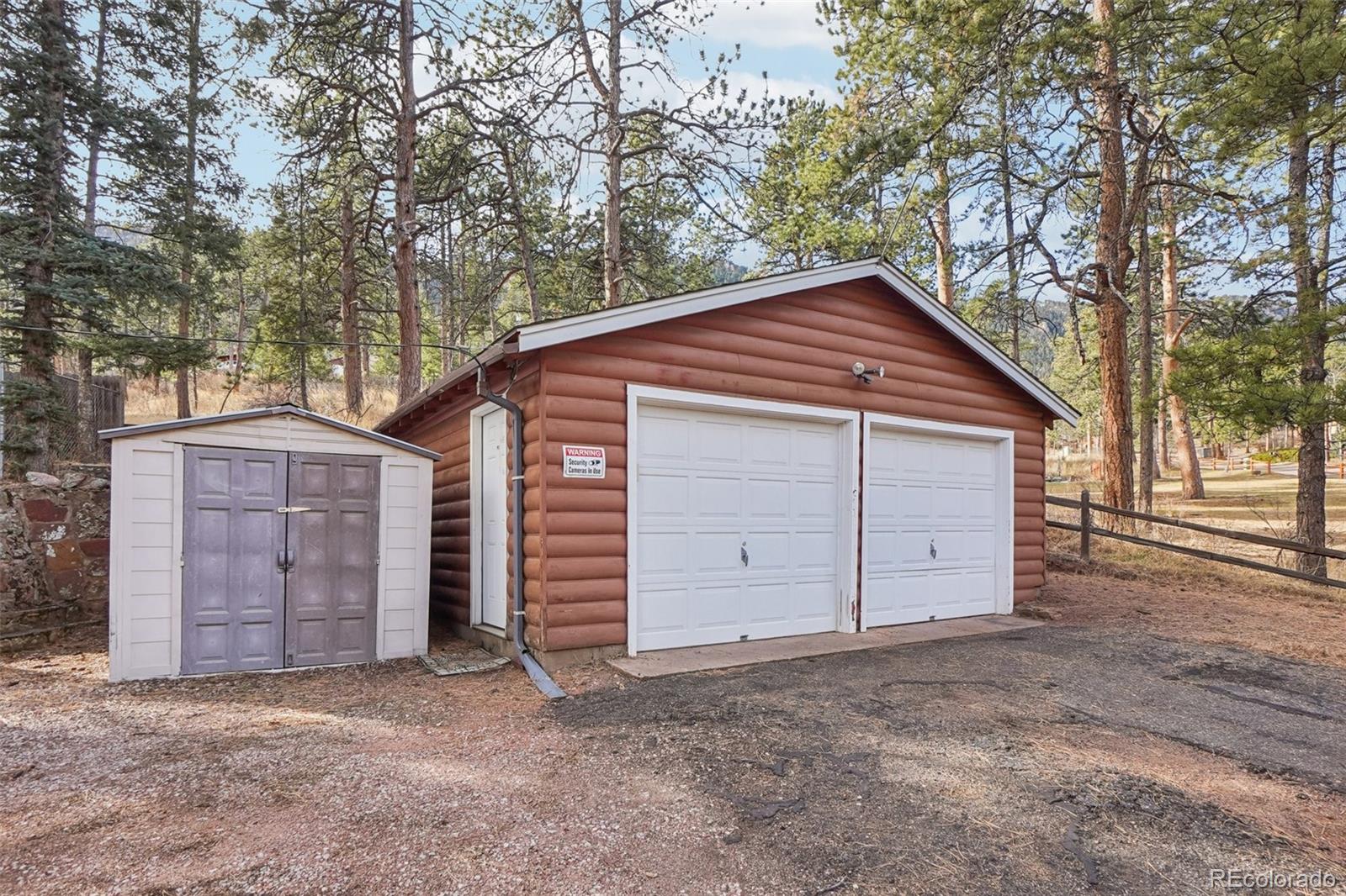 9025 Picabo Road Cascade, CO 80809 - Photo 42 of 44 a wooden house with a large tree and wooden fence