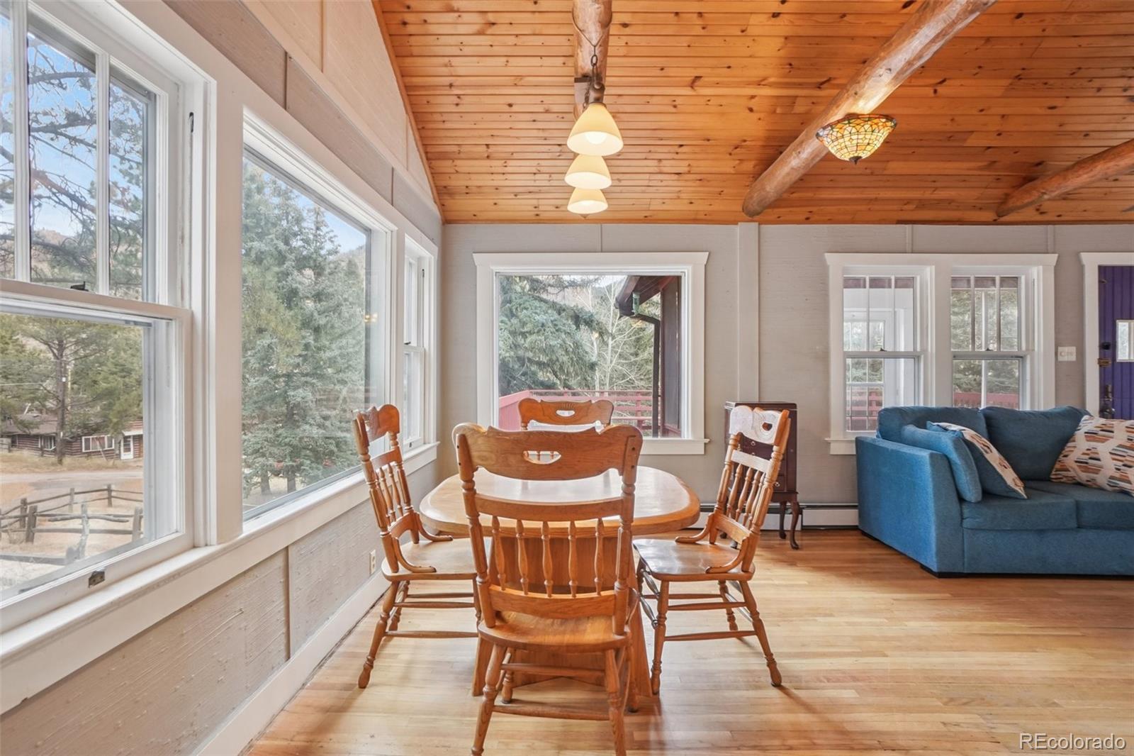 9025 Picabo Road Cascade, CO 80809 - Photo 7 of 44 a view of a dining room with furniture a chandelier and wooden floor