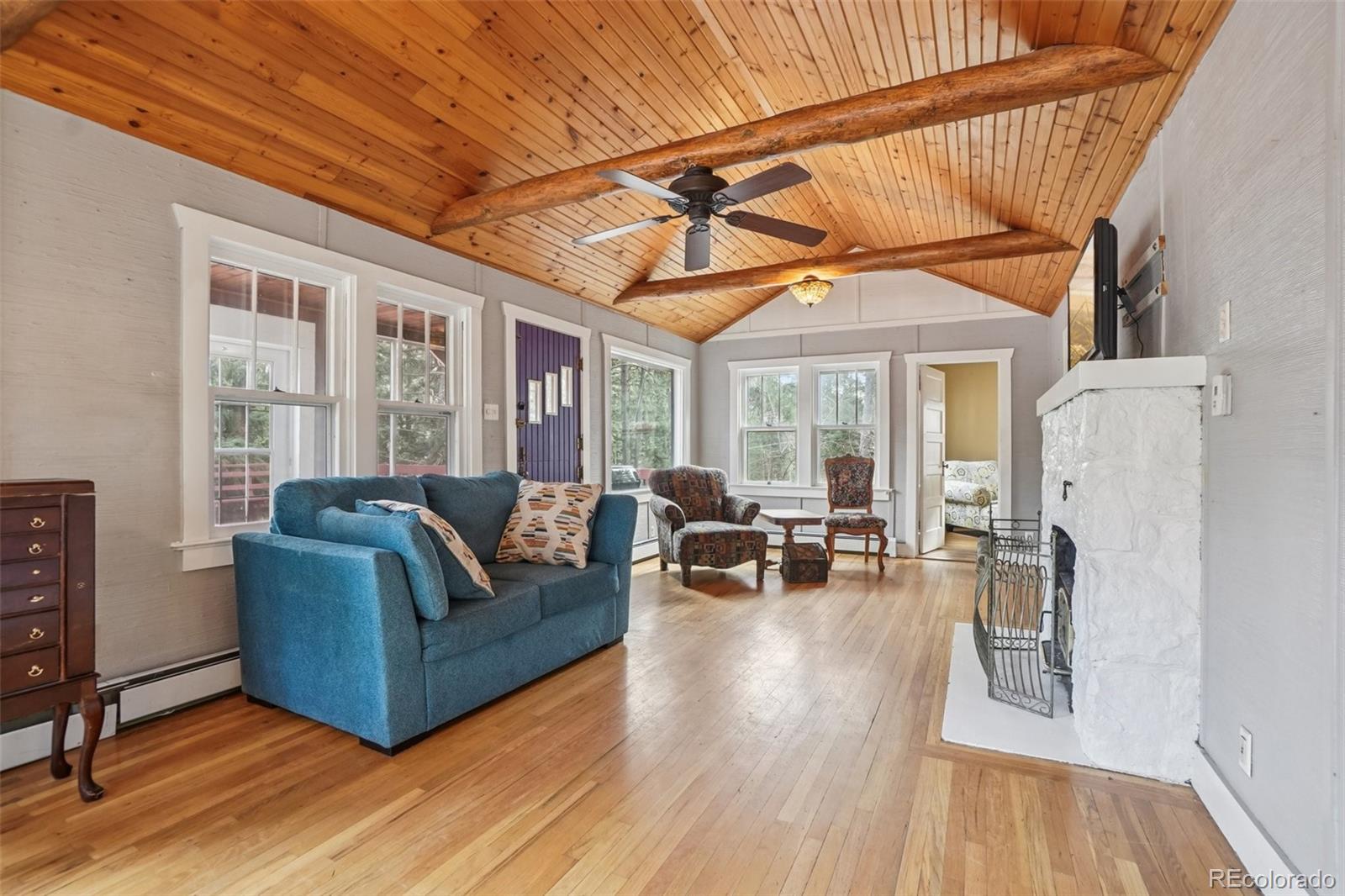 9025 Picabo Road Cascade, CO 80809 - Photo 9 of 44 a living room with furniture a fireplace and wooden floor
