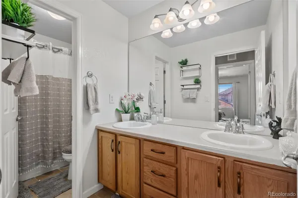 a bathroom with a sink vanity granite and a shower