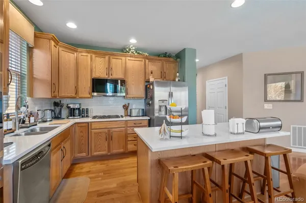 a kitchen with stainless steel appliances granite countertop a sink a stove and a refrigerator