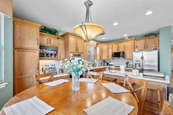a dining room with furniture a chandelier and wooden floor