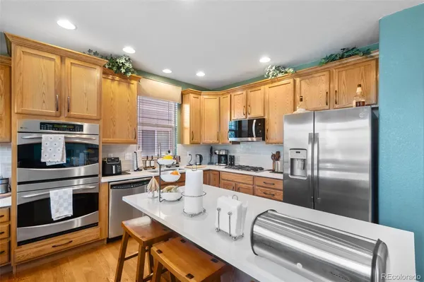 a kitchen with stainless steel appliances a refrigerator a stove a sink and white cabinets