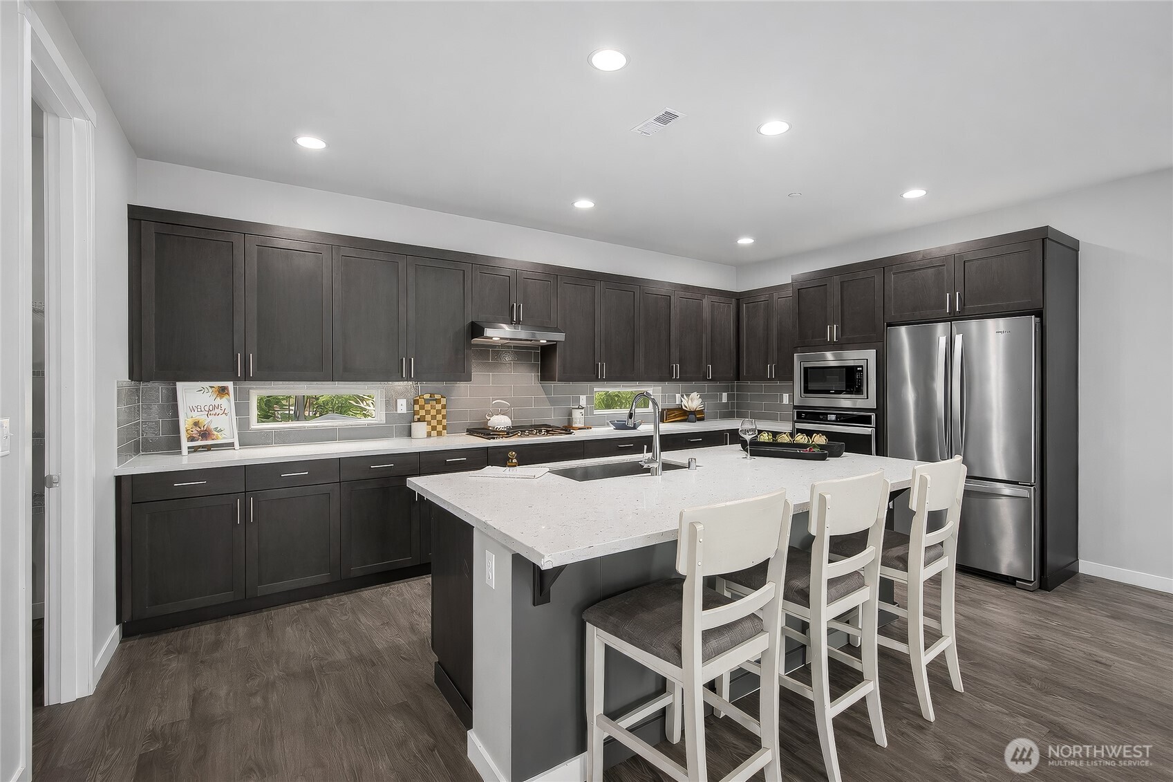 130 198th Street Southeast, Unit 5 Bothell, WA 98012 - Photo 8 of 40 a kitchen with stainless steel appliances granite countertop a table chairs sink refrigerator and cabinets