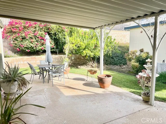 a view of a patio with a table chairs and garden