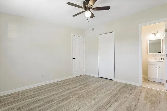 a view of a room with wooden floor and a ceiling fan