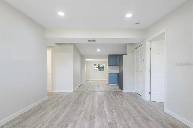 a view of a big room with wooden floor and a window