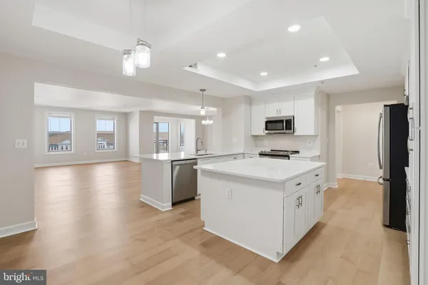 a kitchen with stainless steel appliances white cabinets a sink and a stove