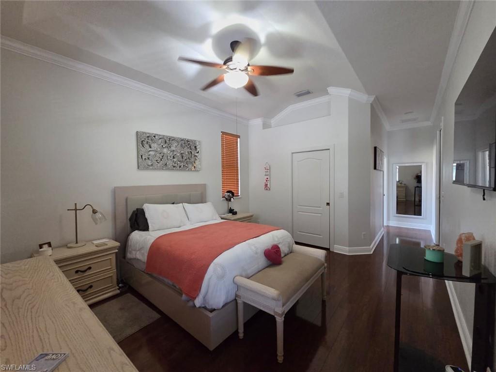 15437 Cortona Way Naples, FL 34120 - Photo 20 of 29 a bedroom with a bed and a chandelier