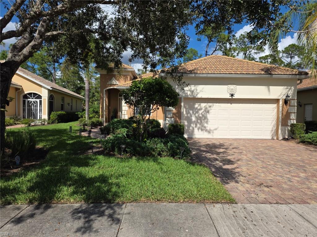 15437 Cortona Way Naples, FL 34120 - Photo 2 of 29 a front view of a house with a yard and garage