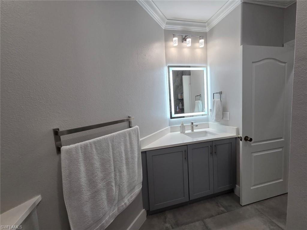 15437 Cortona Way Naples, FL 34120 - Photo 26 of 29 a bathroom with a double vanity sink and mirror
