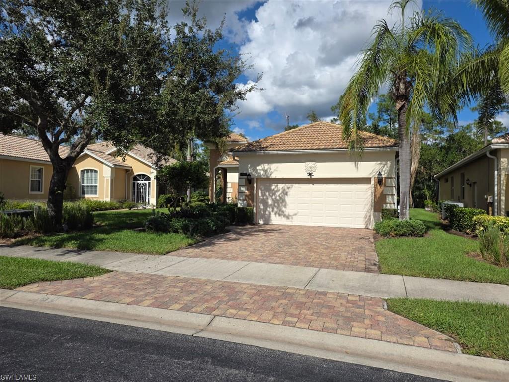 15437 Cortona Way Naples, FL 34120 - Photo 28 of 29 a front view of a house with a yard and garage