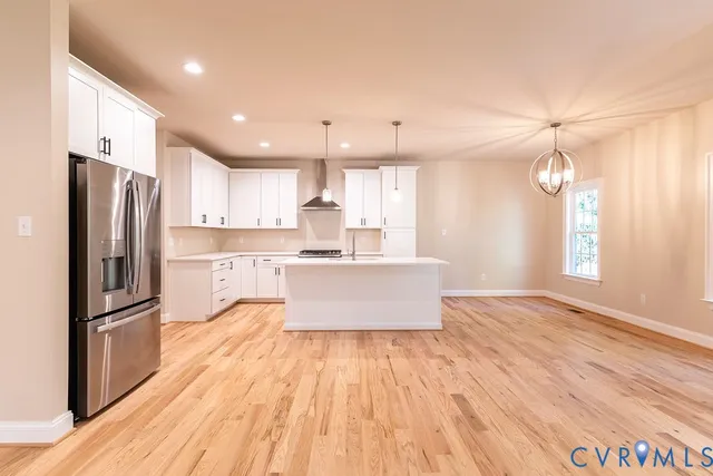 a large kitchen with kitchen island a large counter space and stainless steel appliances