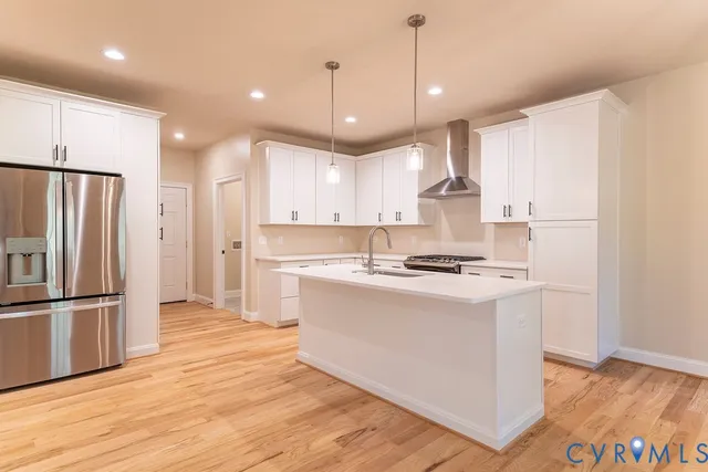 a kitchen with stainless steel appliances granite countertop a refrigerator a stove a sink and a refrigerator