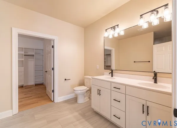 a bathroom with a double vanity sink mirror and toilet