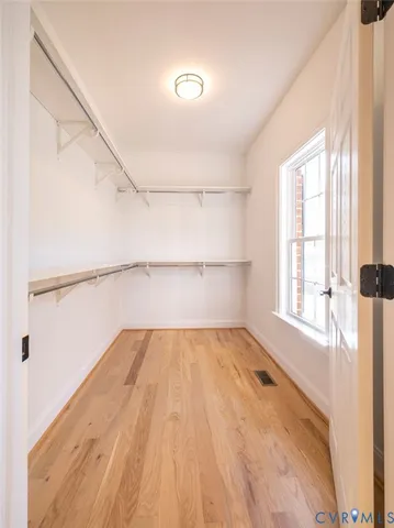 a view of a room with wooden floor and small window