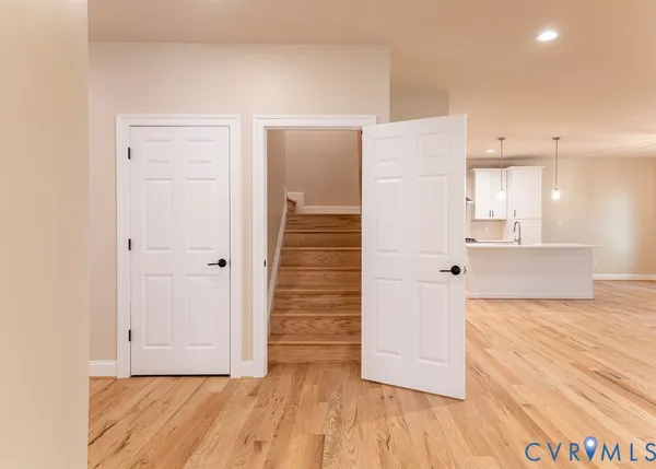 a view of a hallway with wooden floor and staircase