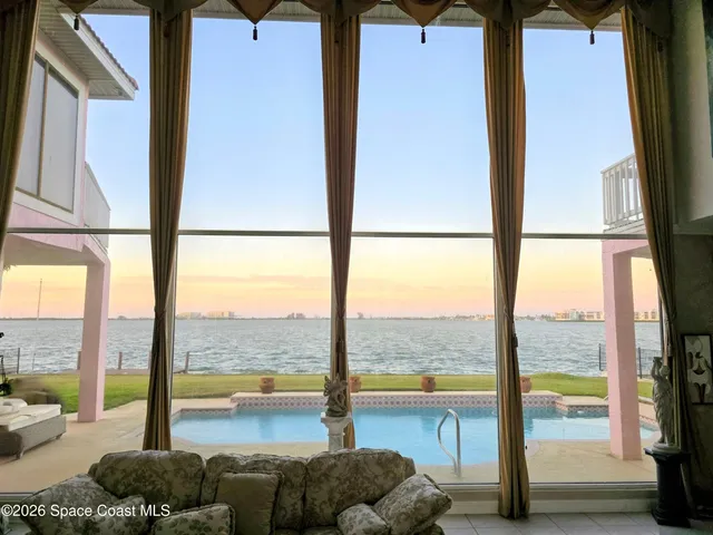 a living room with furniture and floor to ceiling windows