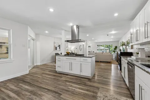 a kitchen with stainless steel appliances kitchen island granite countertop a stove a sink and a refrigerator