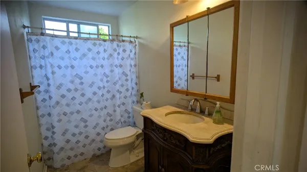 a bathroom with a granite countertop sink toilet and a mirror