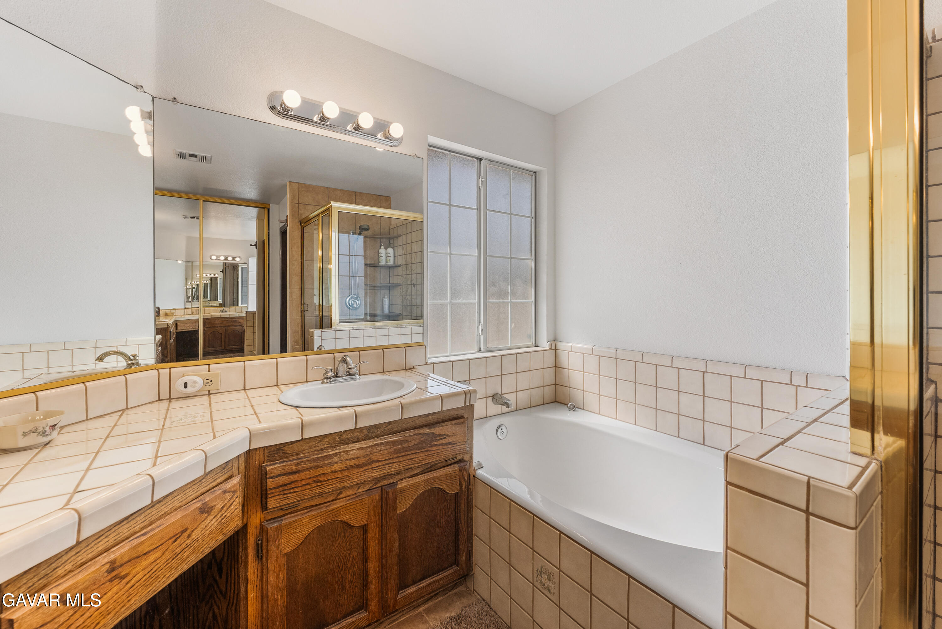 40508 154th Street East Lancaster, CA 93535 - Photo 17 of 20 a bathroom with a granite countertop sink and a bathtub