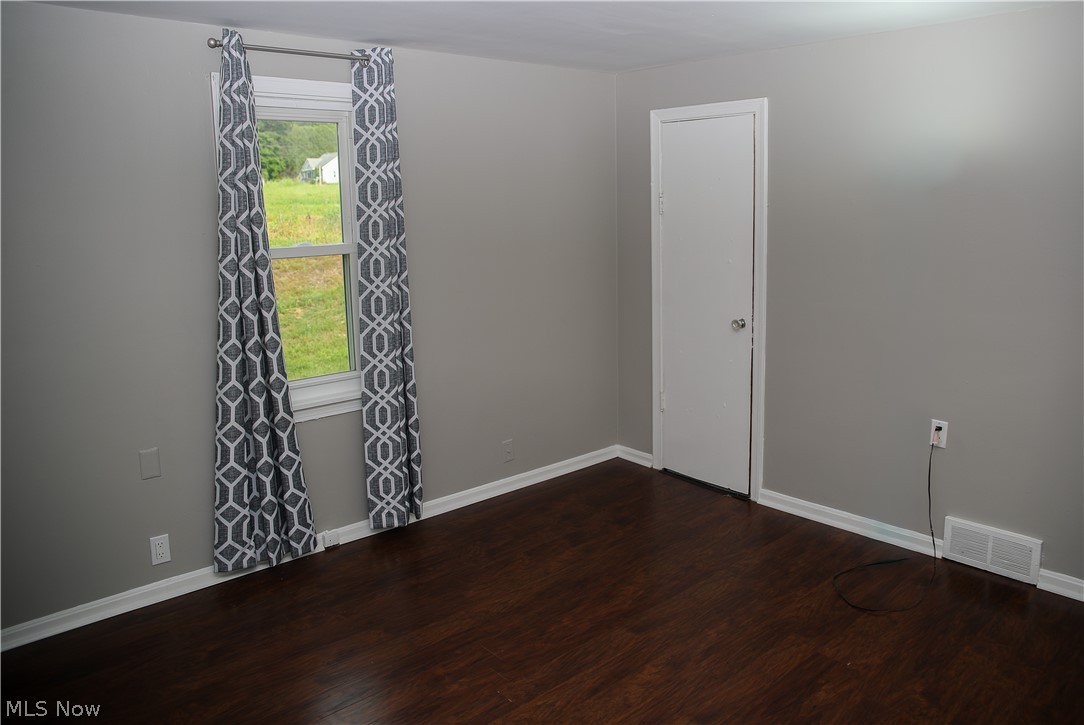 1087 Krumroy Road Akron, OH 44306 - Photo 8 of 23 Room featuring dark wood-finish flooring, light gray wall paint, and white baseboards
