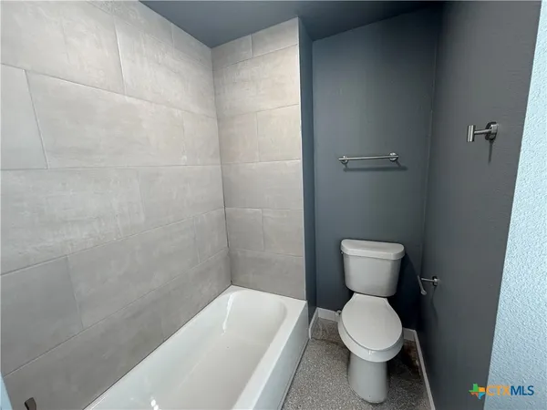 a bathroom with a toilet and a bathtub