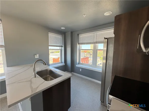 a kitchen with a sink a window and cabinets