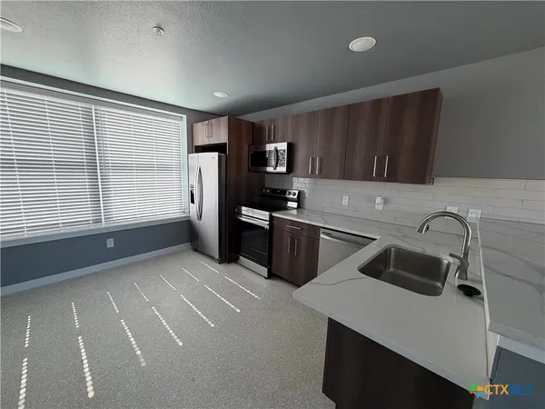 a kitchen that has a sink and a stove in it