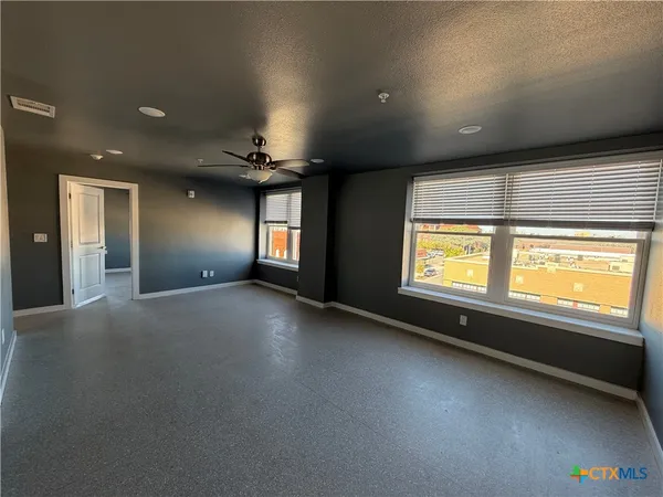 an empty room with a empty space and windows