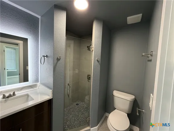 a bathroom with a toilet a sink and shower